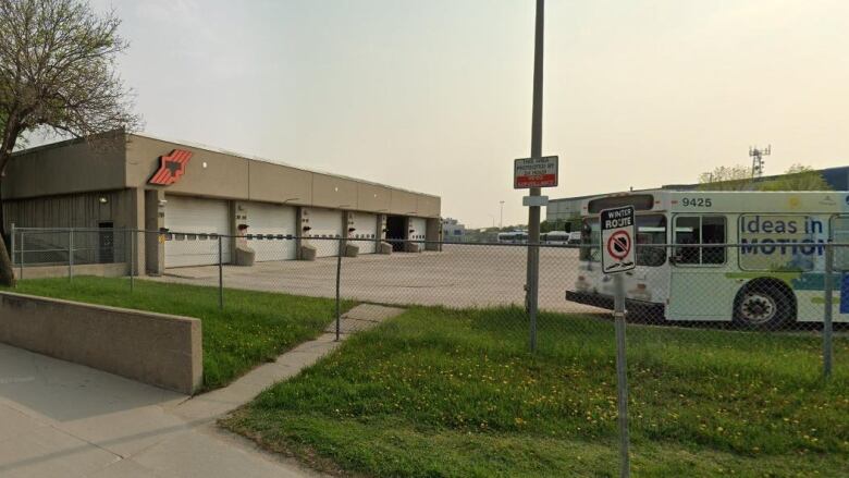 A bus is parked outside a garage.