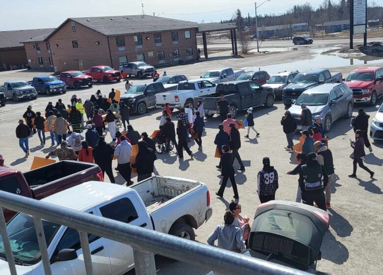 People on a parking lot holding signs.