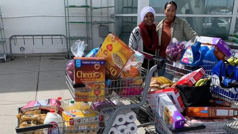 Members of the United African Diaspora run a grocery program. The group has had to shift to providing less food to each person because demand is increasing. 