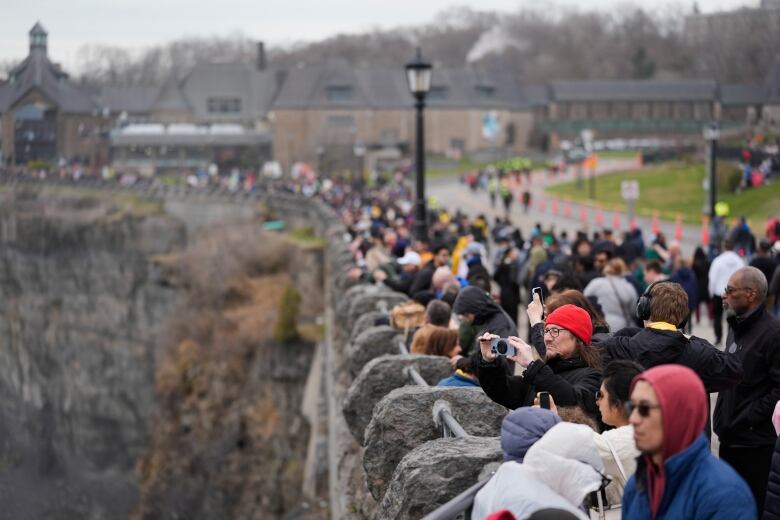 people stand along wall