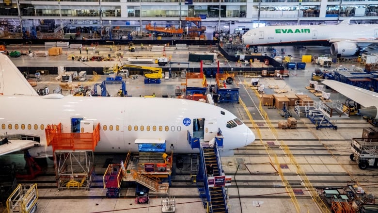 Employees assemble Boeing 787 jets at a plant.