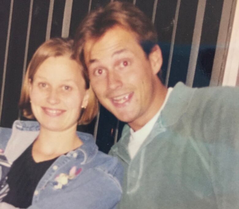 An older photograph of a young man and woman smiling at the camera.