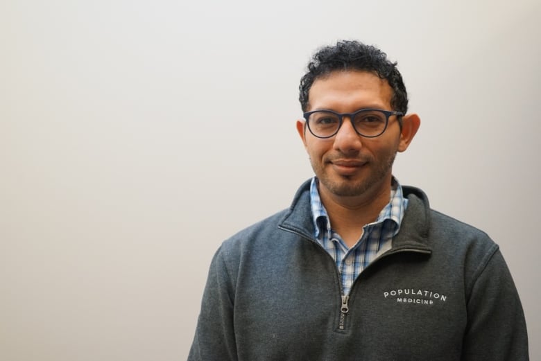 A man wearing glasses smiling.