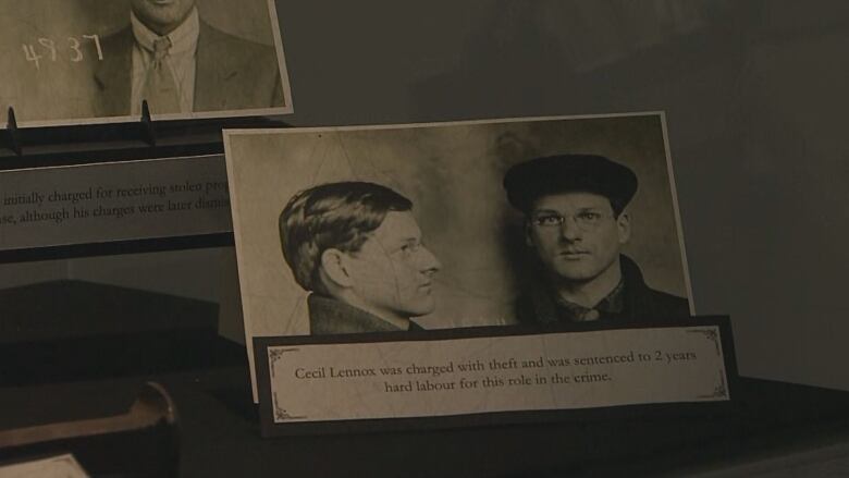 two mug shots of a man with glasses in a glass case. a card below reads 