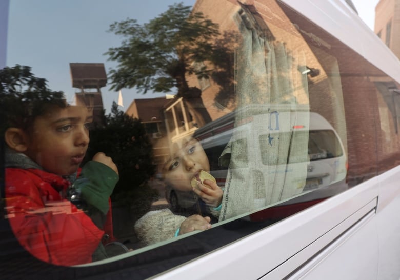 A Palestinian girl with her brother who was evacuated from Gaza amid the ongoing conflict between Israel and the Palestinian Islamist group Hamas look out of the bus on their way to the airport, as wounded Palestinians are transported to Rome by military aircraft from Cairo International Airport, at the Italian hospital Umberto I of Cairo, Egypt