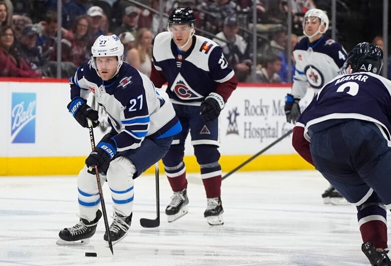 Hockey players skate on the ice.