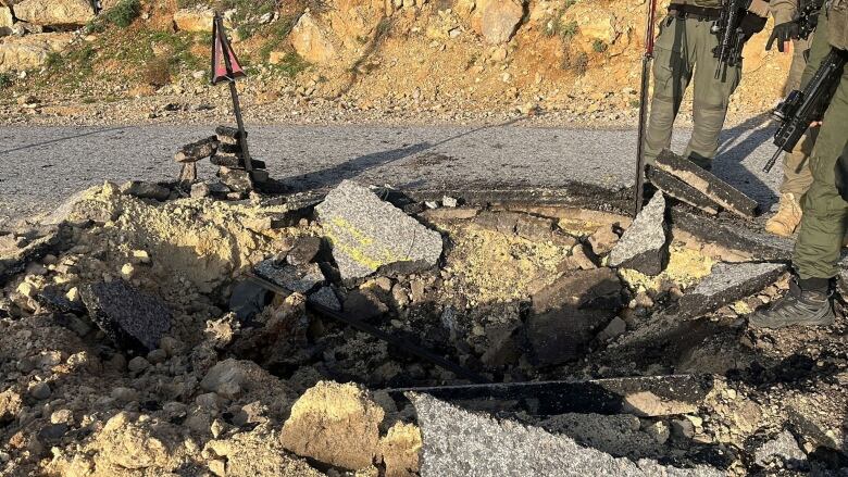 A crater in a roadway is shown.