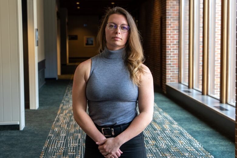 A woman with glasses poses for a photo.