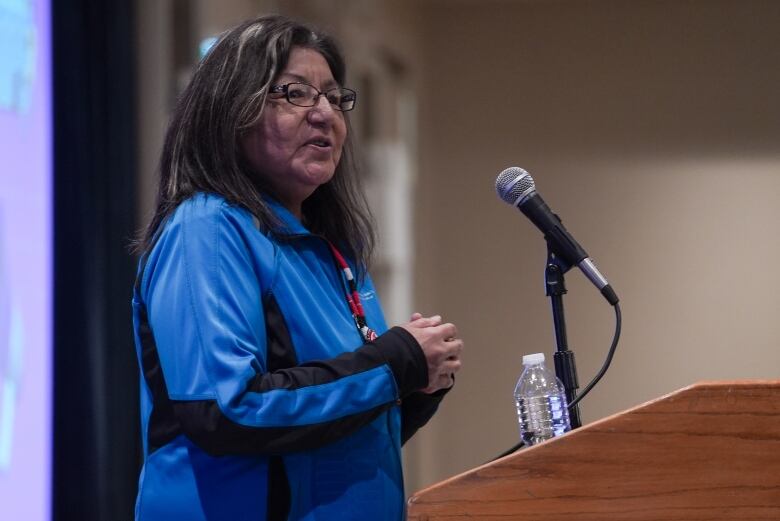 A woman speaks at a podium. 