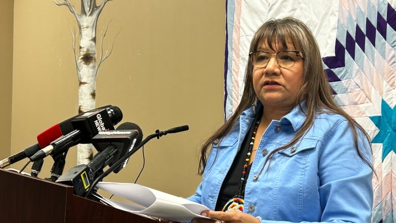 A woman stands behind a podium.