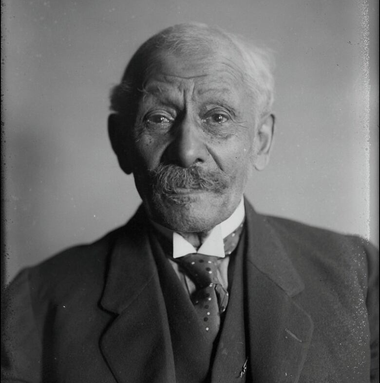 An old photo of an elderly man in a suit.