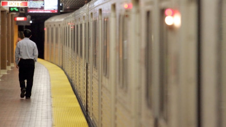 A subway car is seen on the tracks inside a subway station.