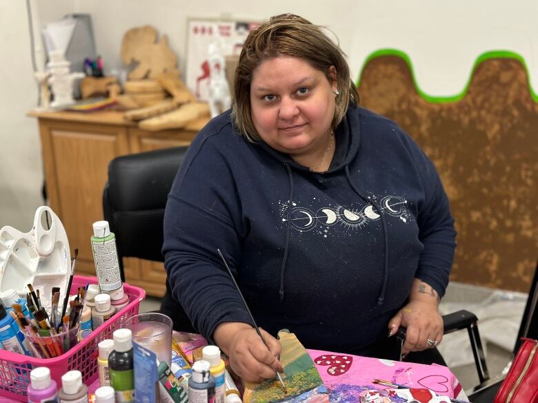 A woman painting a piece of wood.