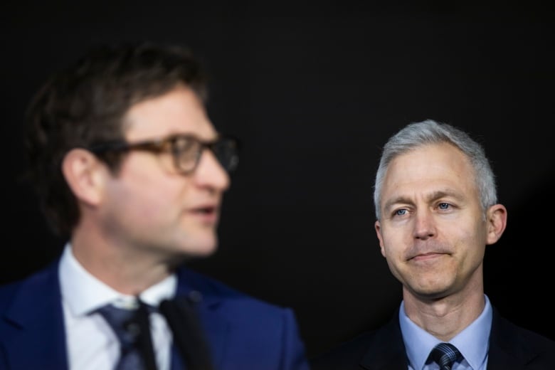 Two men in suits stand at a podium.