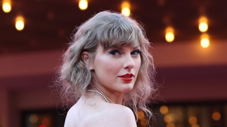 A woman looks over her shoulder toward the camera. 