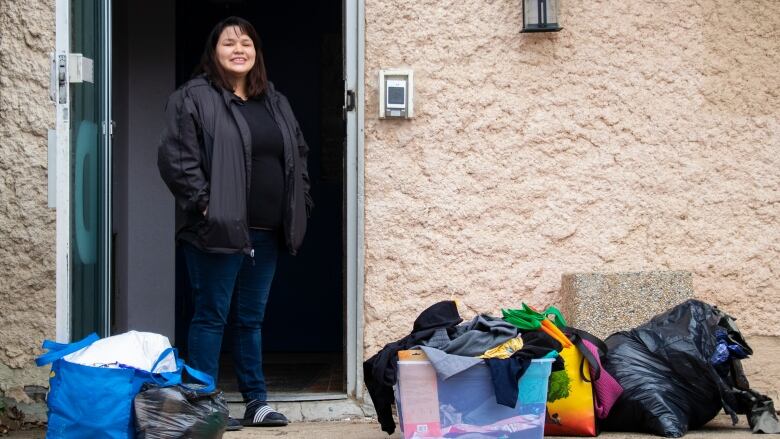 A woman stands in a door way.