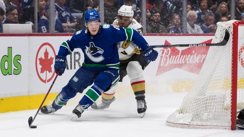  Vasily Podkolzin, front, of Russia, is checked by Vegas Golden Knights' Alec Martinez during the third period of an NHL hockey game in Vancouver, B.C., Sunday, April 3, 2022. 