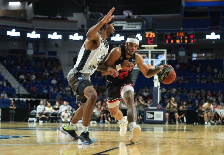 Calgary Surge's Sean Miller-Moore, right, moves the ball past Scarborough Shooting Stars' Isiaha Mike during the first half of the CEBL basketball championship final, in Langley, B.C.