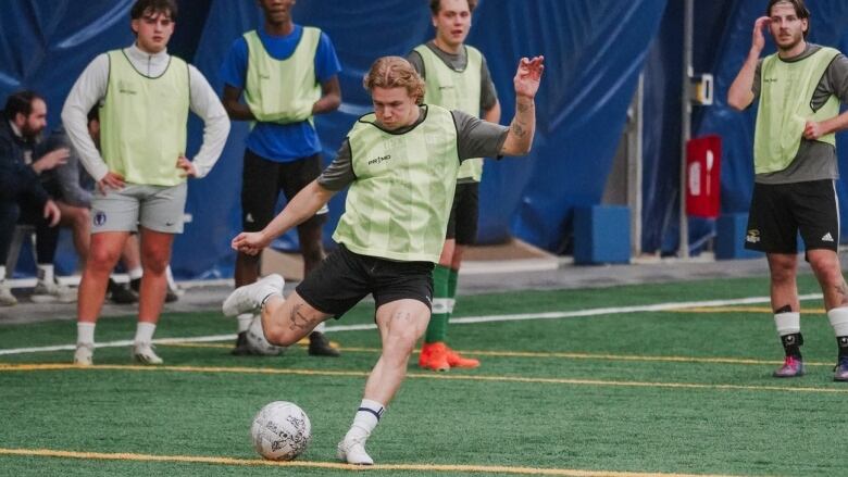 A man kicks a soccer ball 