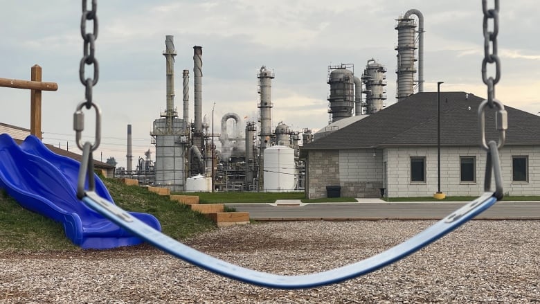 Swing in the foreground and a chemical plant in the background