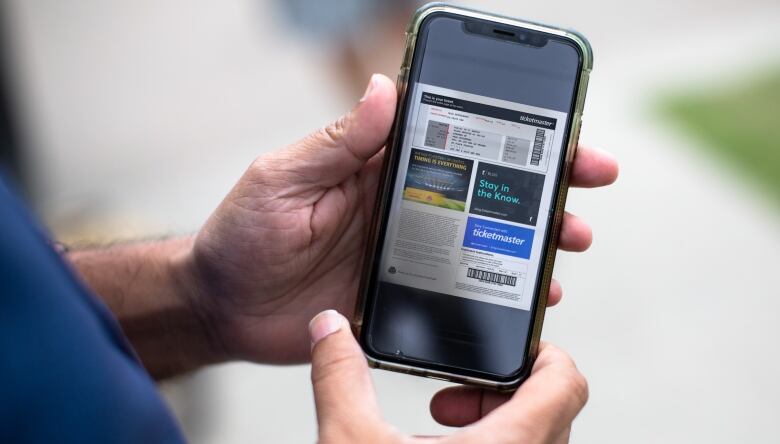 A hand holding a cell phone with the Ticketmaster ticket app visible with a Paul McCartney ticket. 