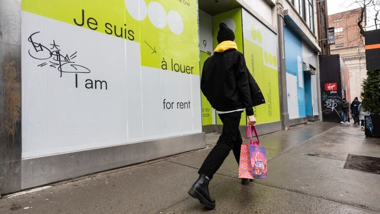 A shopper walks past vacant storefronts.