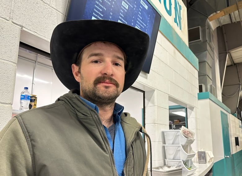 A man in a cowboy hat stands by the concession.