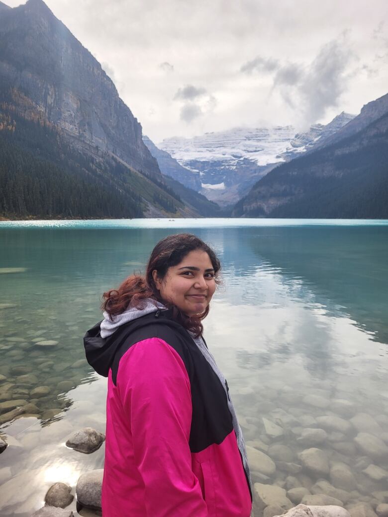 A woman standing in front of scenic mountains. 