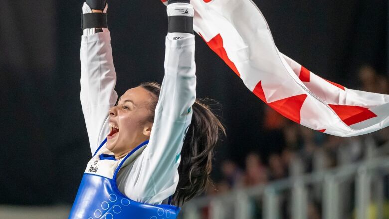 A woman screams while holding the Canadian flag.