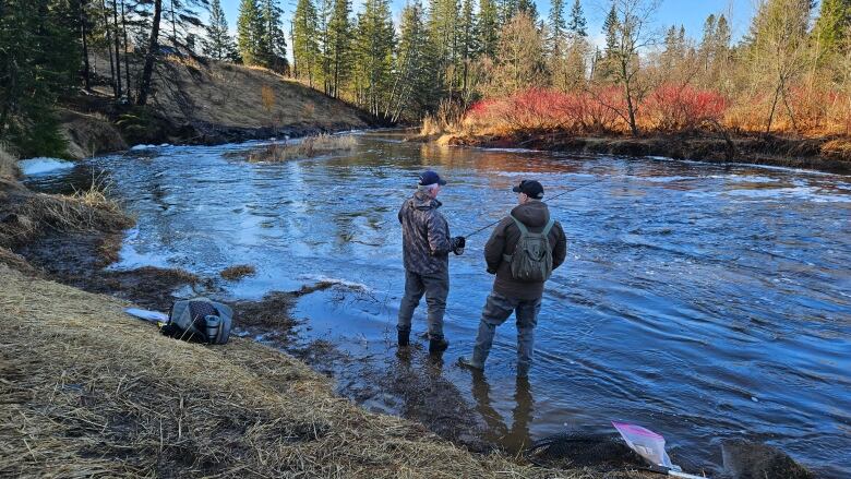 Two men fish. 