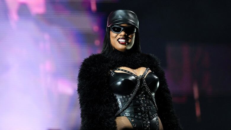 A woman performing on stage looks out at the audience.