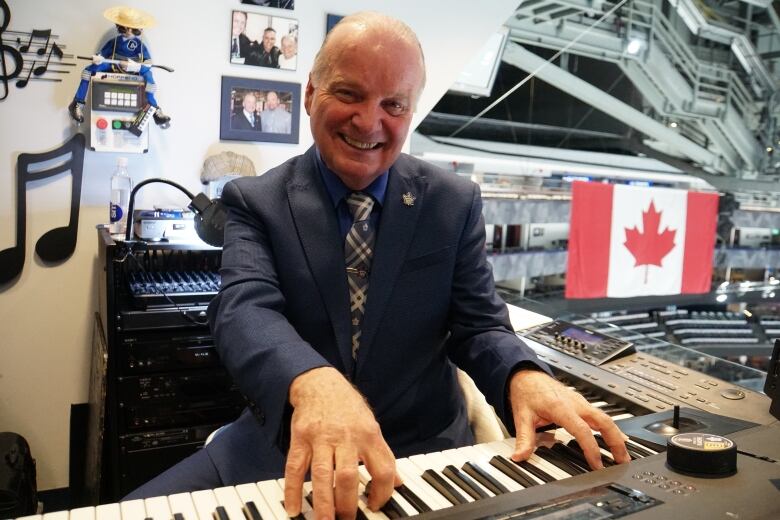 A man at a keyboard in an arena.