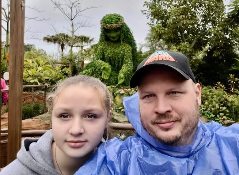 A 15 year old girl and her dad look into the camera