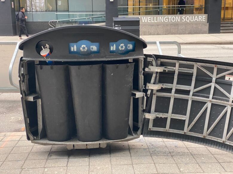 An open litter sorting bin with a plastic cup stuck in one of the flaps.