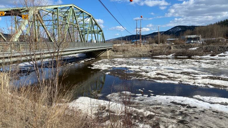 A highway bridge is seen over an ice-filled river.