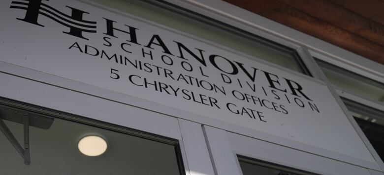 A sign on a building which reads Hanover School Division Administration Office is shown on the front of a building 