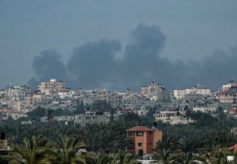 Smoke billows above a city.