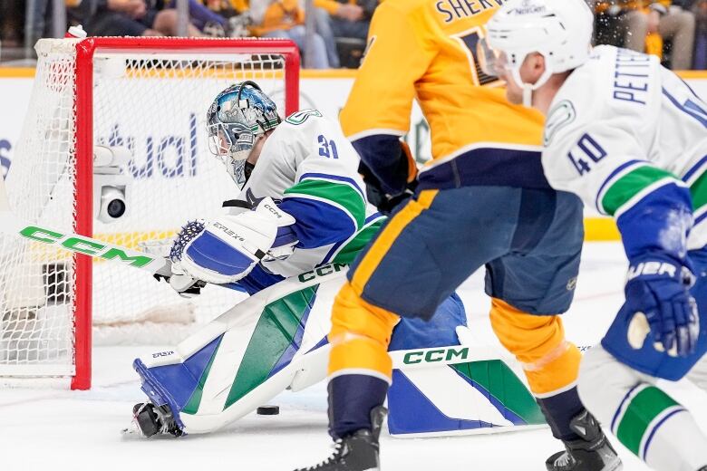 A goalie dives on a puck.