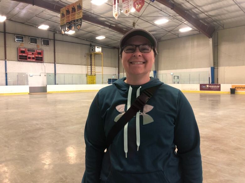 Woman in hockey arena poses for a picture