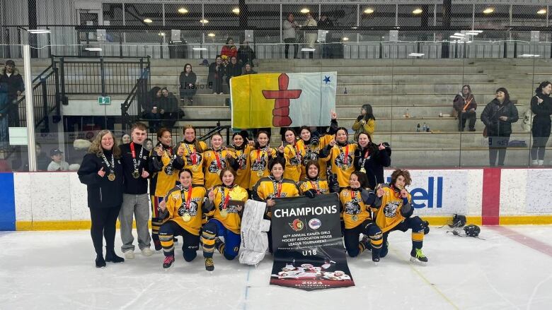 Iqaluit Blizzards Under 18 female team pose on the rink 