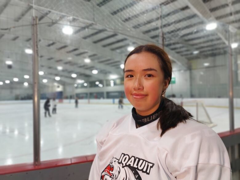 Leetia Eegeesiak stands rinkside in her Iqaluit Blizzards jersey