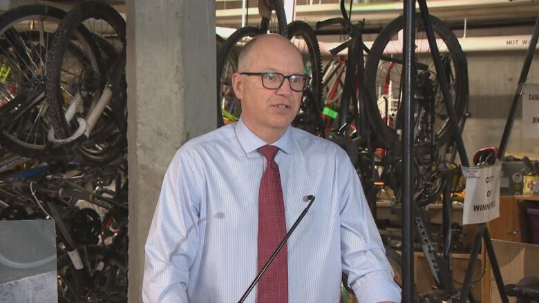 A man stands in front of a microphone in a bike shop.