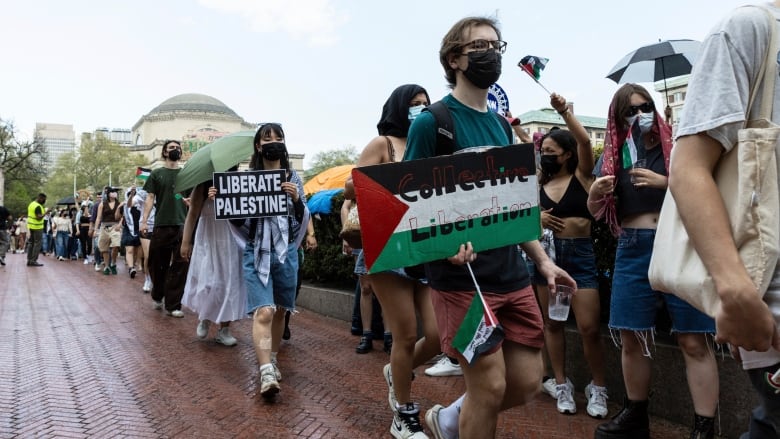 Student protesters march around an encampment at Columbia University.