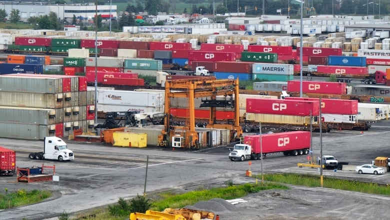 A railway yard filled with trains and shipping containers.