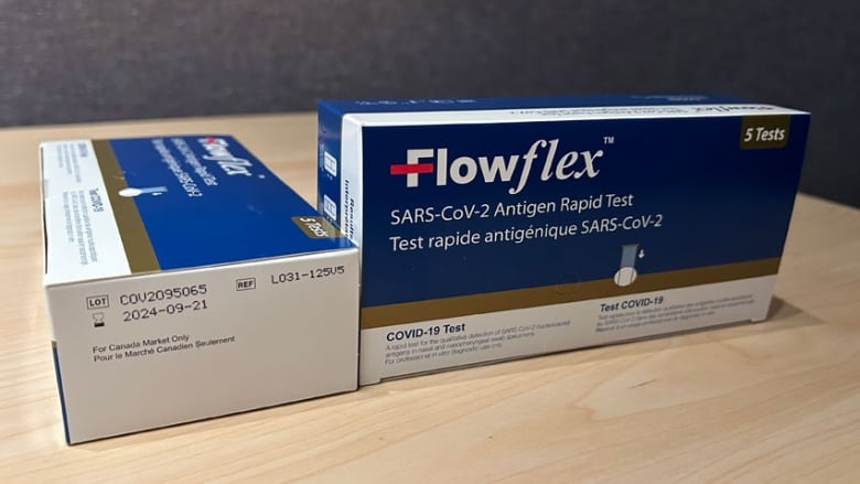 Two boxes of COVID-19 rapid tests, with one showing the expiry date.