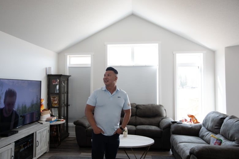 A man stands inside a house. 