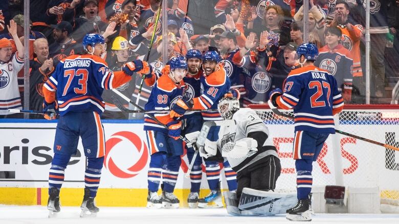 A group of hockey players celebrate a goal.