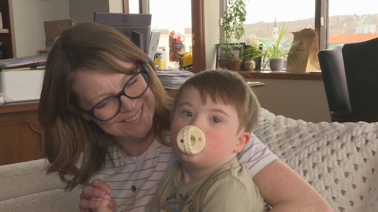 A woman and toddler sit on a couch