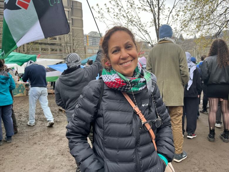 A woman smiles at the camera with a crowd behind her