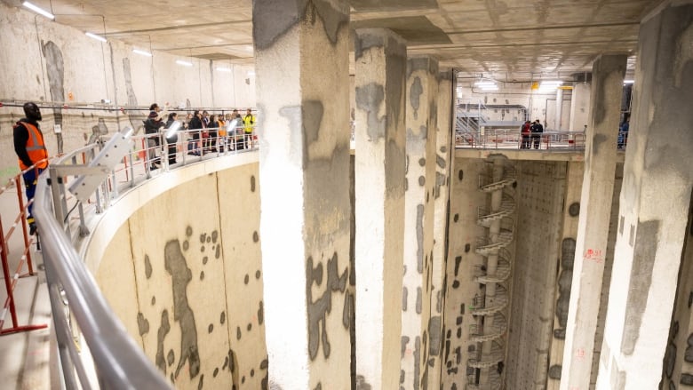 People looking at a water storage basin.